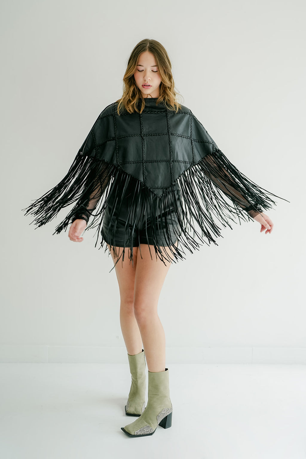 ROMPER Shoemaker poncho in black — styled on model