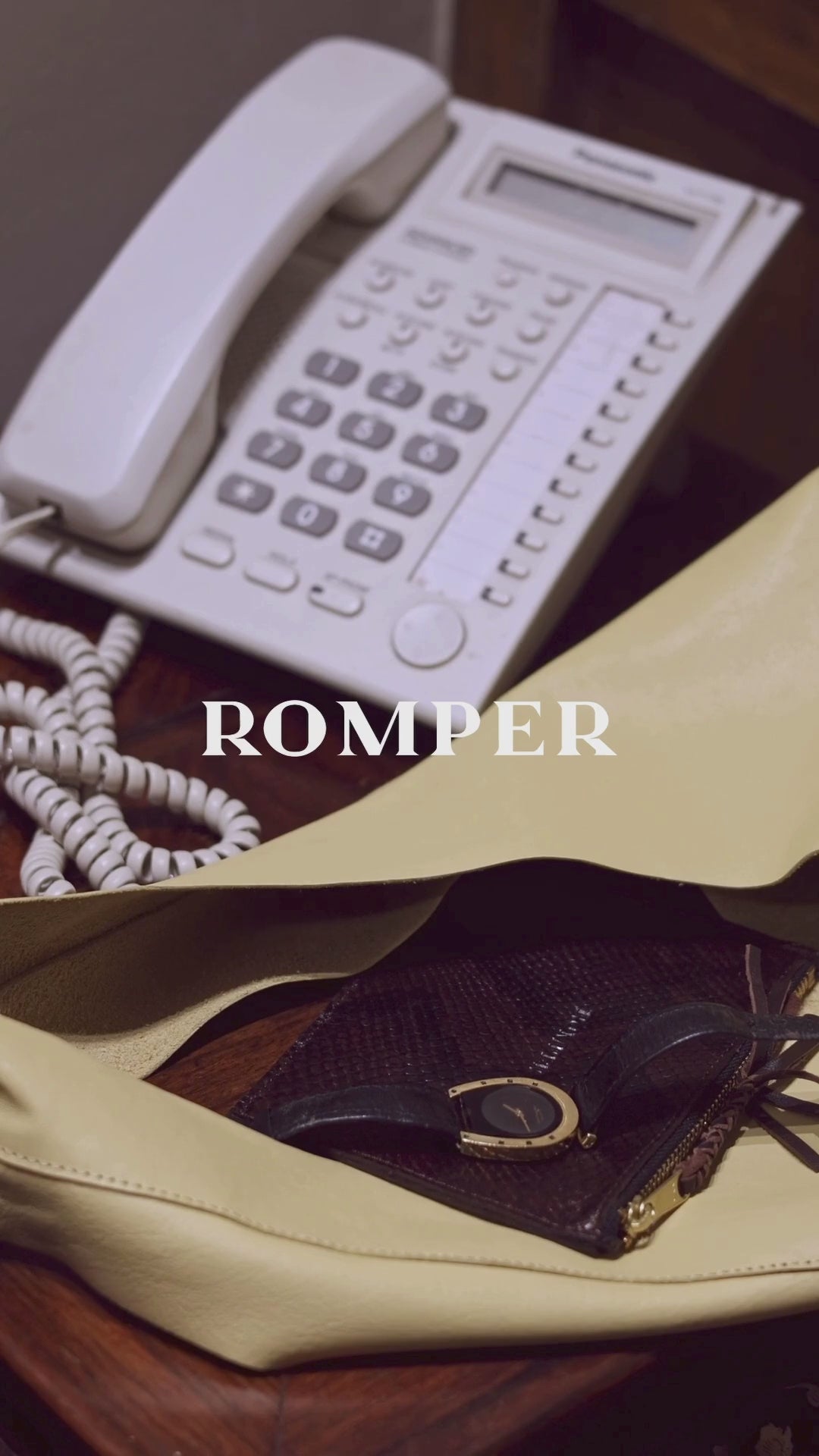Video of a phone ringing with the wallet and margarita tiny bag in butter yellow next to it. A person hangs up the phone wearing the monica shirt jacket in leather. 
